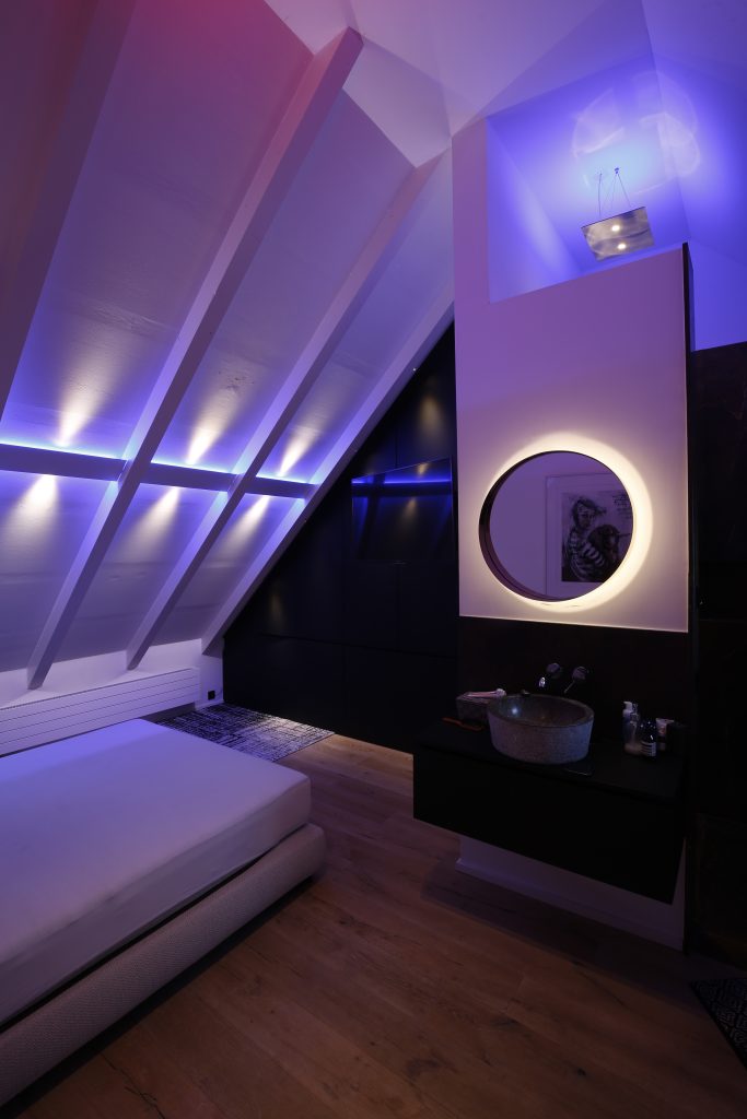Modernes Schlafzimmer mit LED Ambient Beleuchtung in Blau und indirektem Spiegellicht