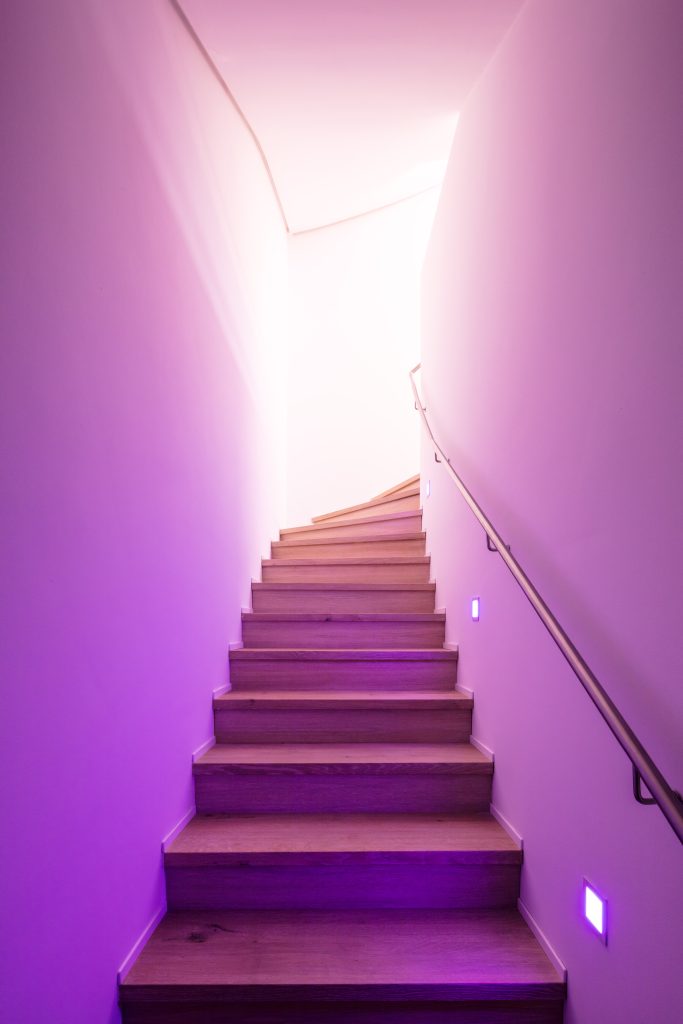 Treppenbeleuchtung mit LED Stufenlichtern und violetter Ambient Light Inszenierung