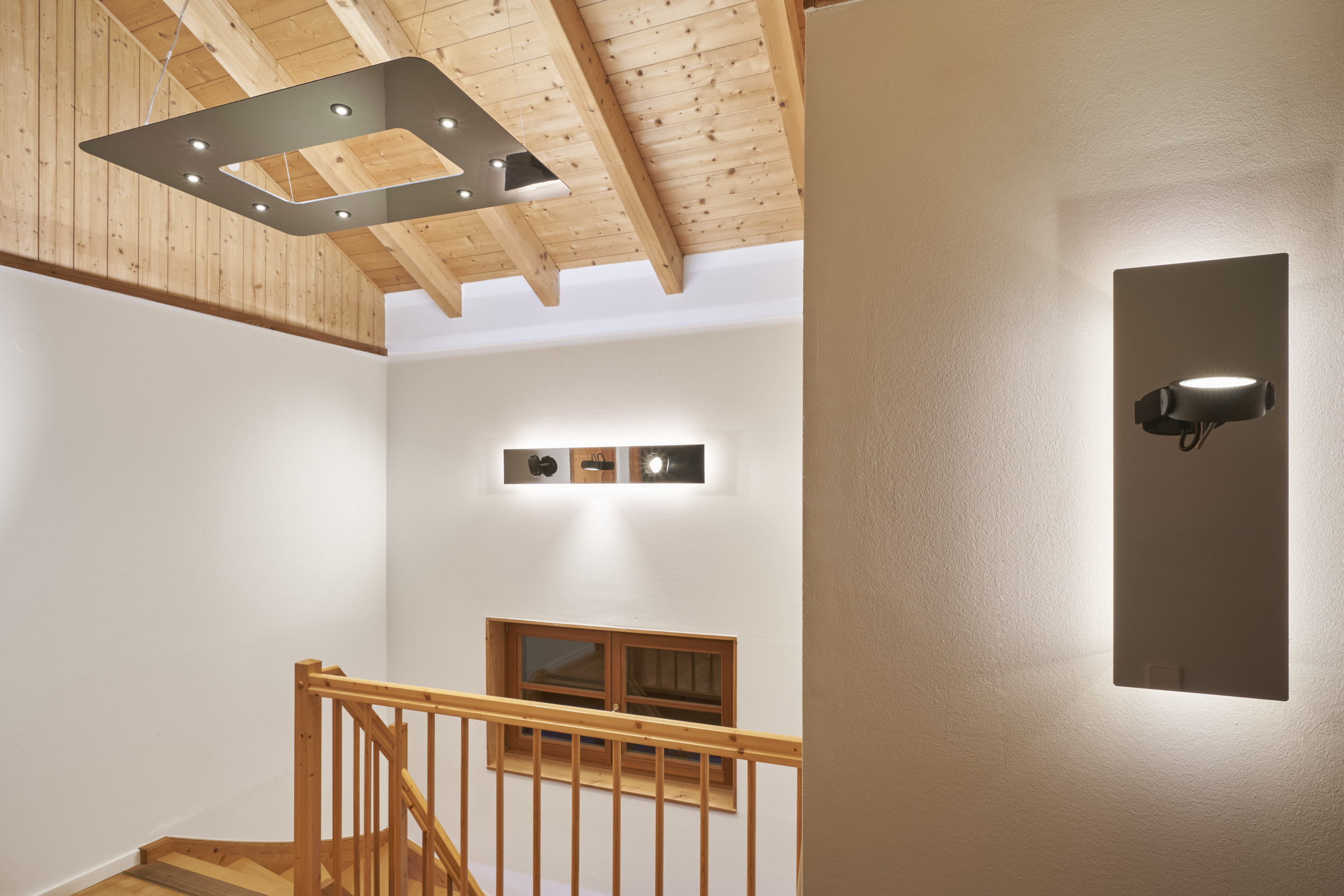 Flyme und Wandleuchten unter einer Holzdecke mit weißer Lichtstimmung