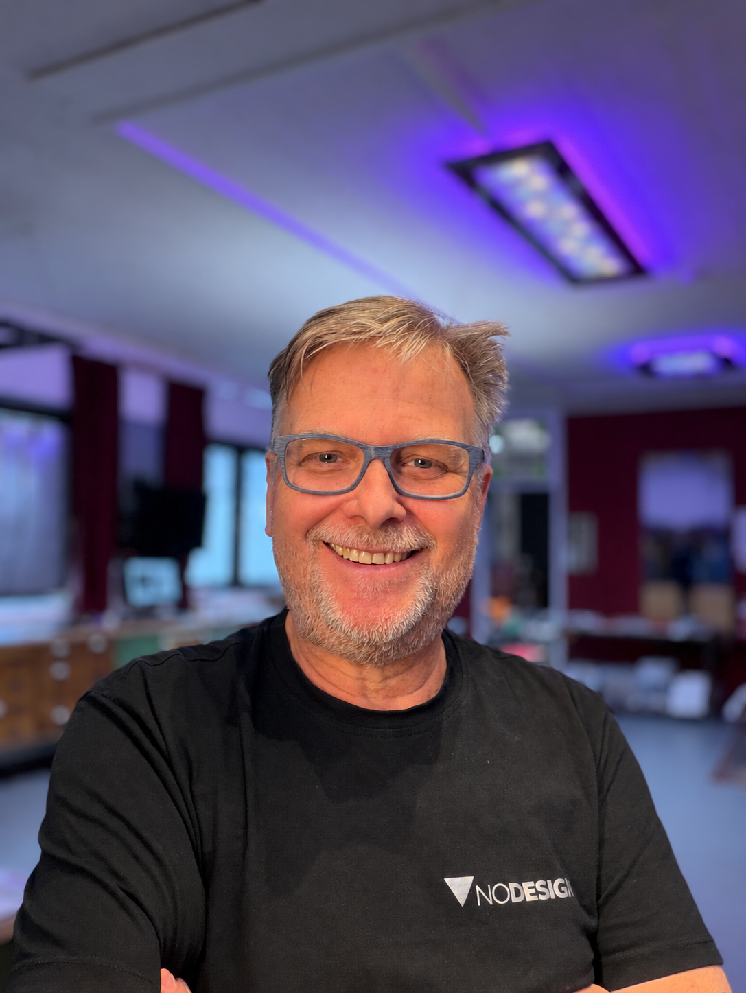 Günter Klügl lächelt in seinem NoDesign-Atelier